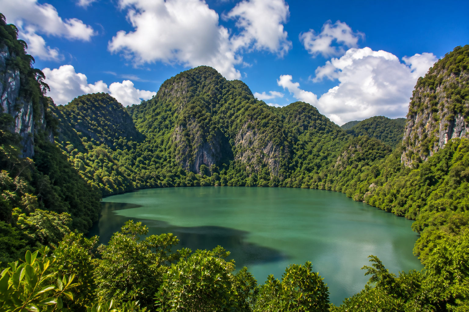 Dayang Bunting lake surrounded by rainforest and limestone hills